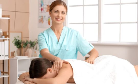quiromasajista en consultorio aplicando quiromasajes a una mujer