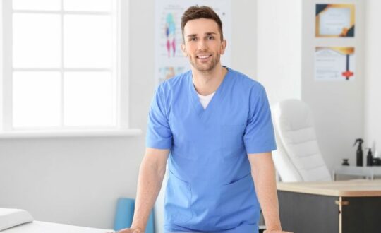 quiromasajista apoyado en una camilla en su consultorio