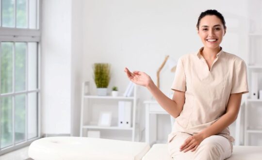 mujer quiromasajista sentada en una camilla explicando los requisitos para estudiar quiromasaje